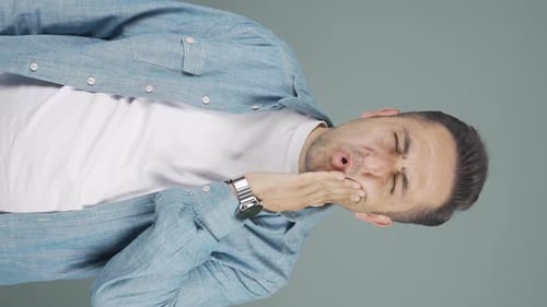 Vidéo verticale d'un homme souffrant de maux de dents.