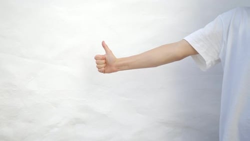 Man In White T-Shirt Gives Thumbs Up and Thumbs Down