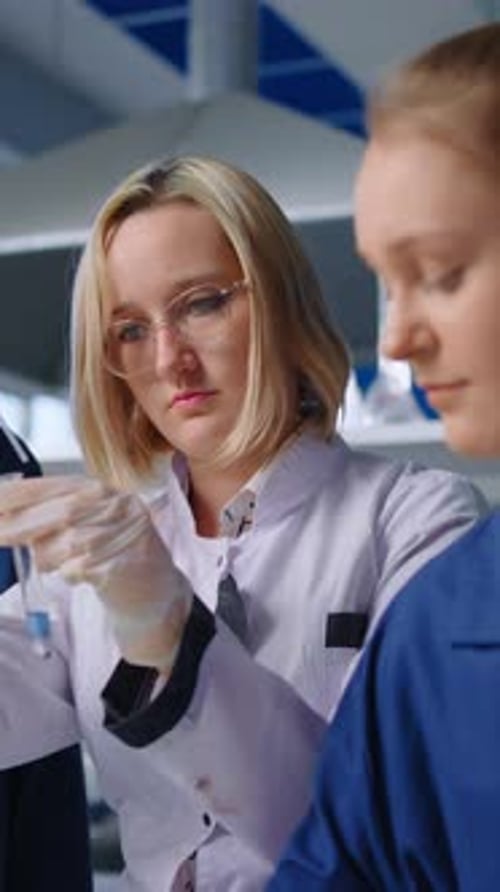 Woman in Lab Coat with Test Tube in Laboratory