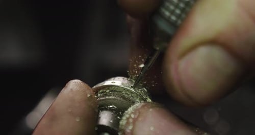 Close up of the hands of a goldsmith while he is working on a diamond ring. Concept: Style, fashio