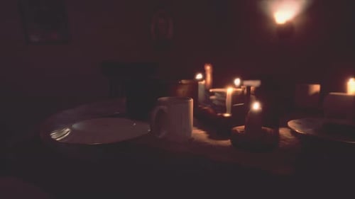 Warm Flickering Candles on Dark Dinner Table
