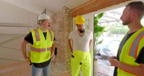 Three Men Discussing Construction in a House
