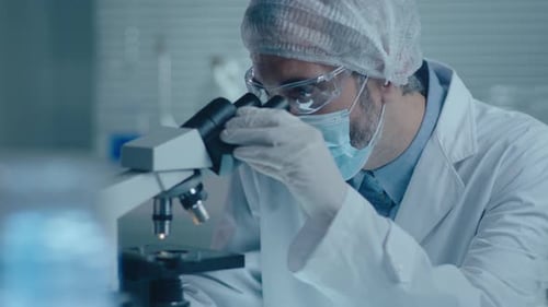 Scientist Working with Microscope in Cool Laboratory