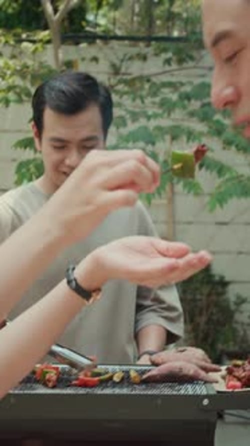 Men Grilling Food and Sharing Samples Outdoors