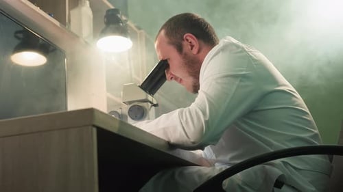 Focused Scientist Using Microscope in Lab