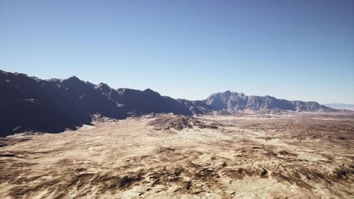 Extensive Arid Plains Under Bright Blue Sky with Distant Peaks