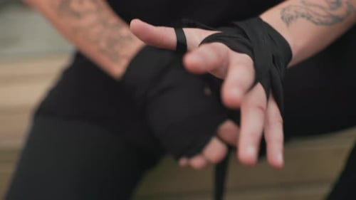Man Wrapping Hands with Bandages for Sports Practice