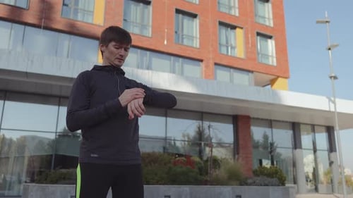Young Man Checking Smartwatch After Outdoor Exercise
