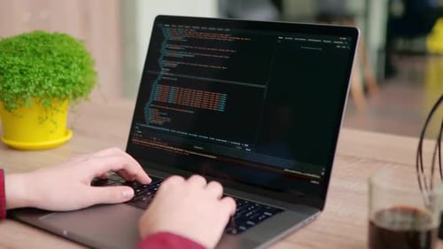 Nahaufnahme von Freelancers Händen, die Code auf der Laptop-Tastatur eingeben, rutscht um die des Entwicklers