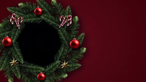 Festliches immergrünes Kranzvideo mit Ornamenten und Zuckerstangen vor sattem roten Hintergrund