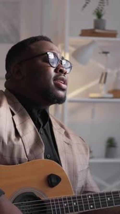Man Playing Guitar and Singing Indoors