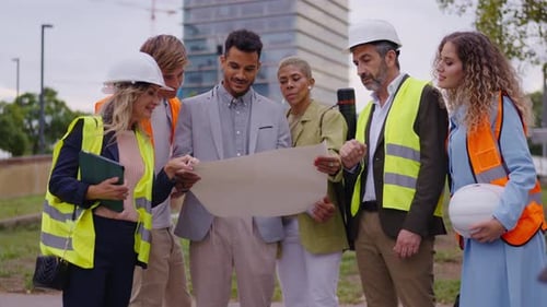 Construction Team Reviewing Blueprints at Building Site