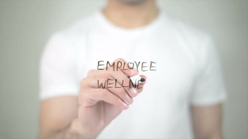 Writing Employee Wellness on Transparent Surface