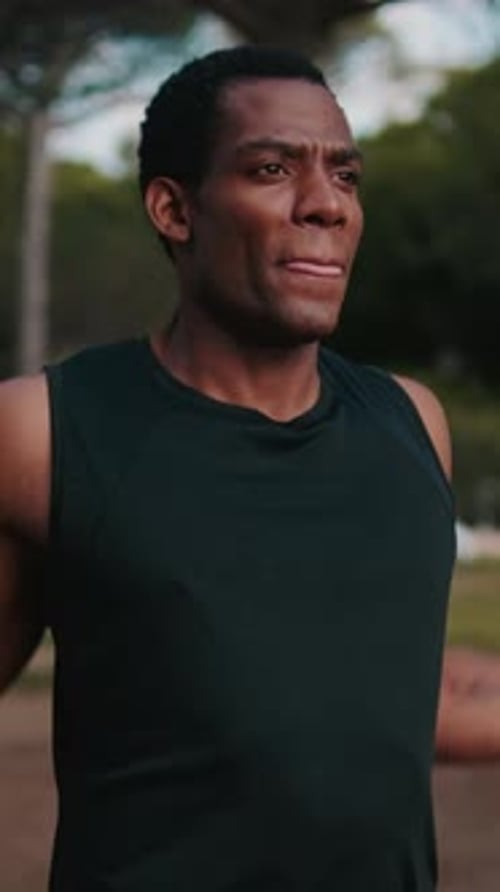 Vertical video, Muscular Man Stretching in the Park