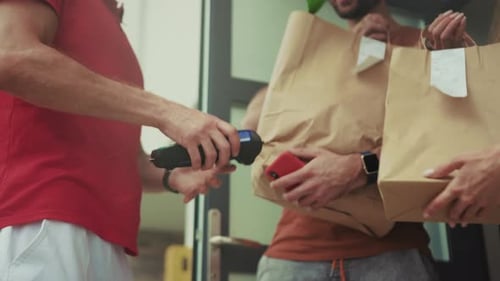 Delivery man holds payment terminal for customer