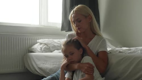 Loving Mother Comforts Young Child Indoors