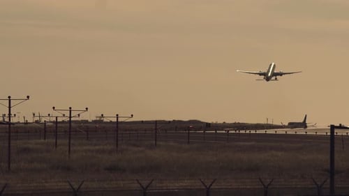 Airplane Taking Off from Airport Runway at Sunset