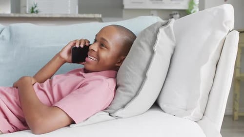 Boy Talking on Phone Lying on Couch