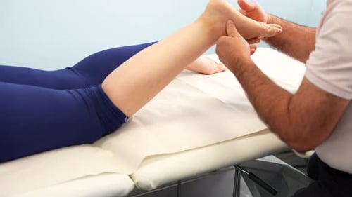 Healthcare Provider Examining Patient's Leg in Clinical Setting