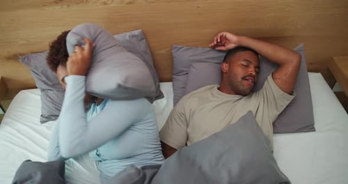 Ci-dessus, agacé et couple au lit avec ronflement, bruit fort ou congestion nasale à la maison