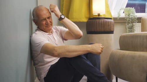 Distressed Adult Sitting on Floor Against Wall