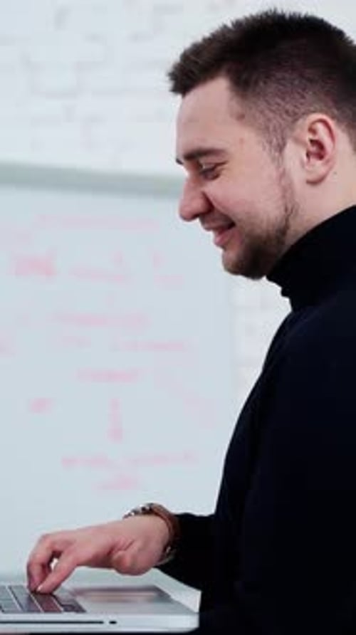 Man Typing on Laptop in Modern Workplace