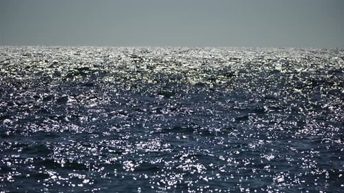 Meeresoberfläche, niedriger Winkel, Blick über klares, azurblaues Meerwasser, Sonnenblendung, abstrakter nautischer Sommerozean
