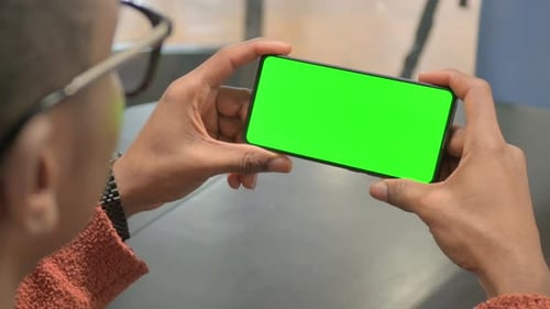 Close up of Man Holding Horizontal Phone with Green Screen
