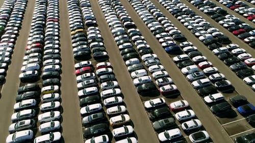 Aerial footage of finished cars ready to be shipped on huge distribution center
