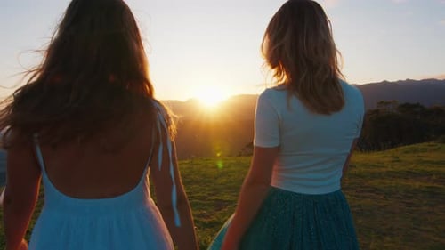 Two Happy Woman Walk in the Mountains at Sunrise