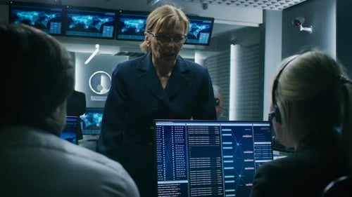 Die weibliche Geschäftsführerin spricht mit Dispatchern für Cybersicherheit, die an einer PC-Show arbeiten