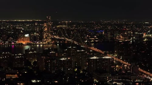 Aerial Night View of New York City's Brooklyn Bridge and East River Highlighting Skyscrapers and