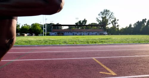 Slow motion close up of an young african male athlete is running on race track in athletics stadiu