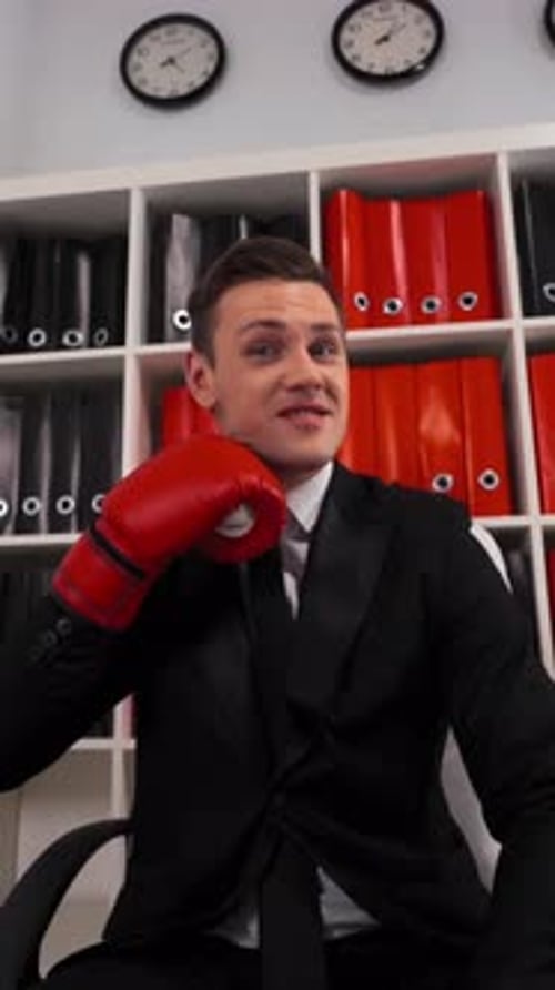 Vertical of Businessman with Boxing Gloves Threatening to You