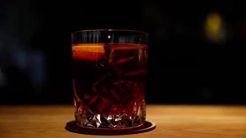Alcoholic drink on the table ready to serve close-up moving shot on a wooden bar table in light moti