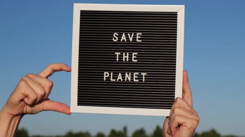 Hands Holding Sign to Save The Planet