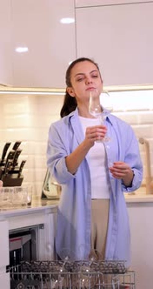 Woman Unloading Dishwasher in Modern Kitchen