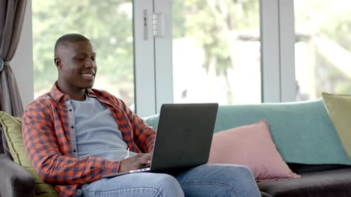 Man Using Laptop on Couch at Home