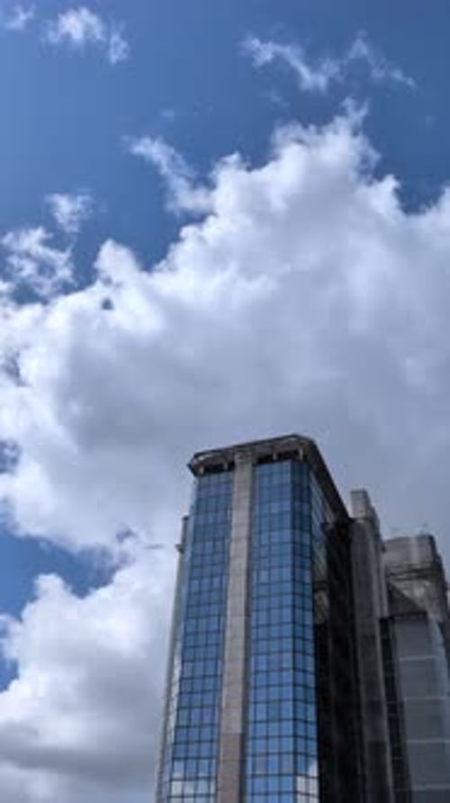 Vertical Video of Tall Corporate Building Against Blue Sky Background with Copy Space Above.