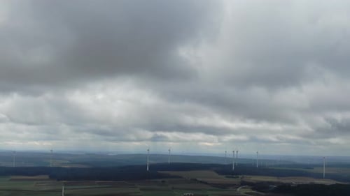 Aerial footage of the field with lots of wind turbines, cloudy day, 4k