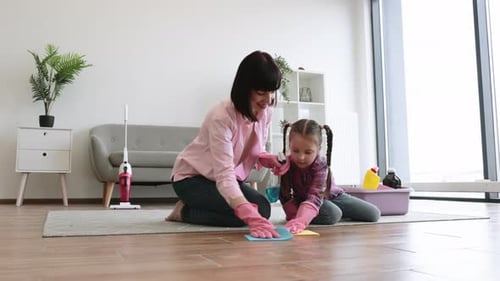 Female with Cute Girl Polishing Floor with Cloth and Spray