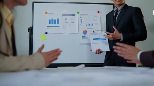 Corporate Team Analyzes Business Data at Whiteboard