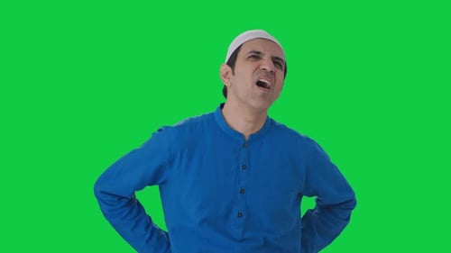 Sick Muslim man suffering from back pain Green screen