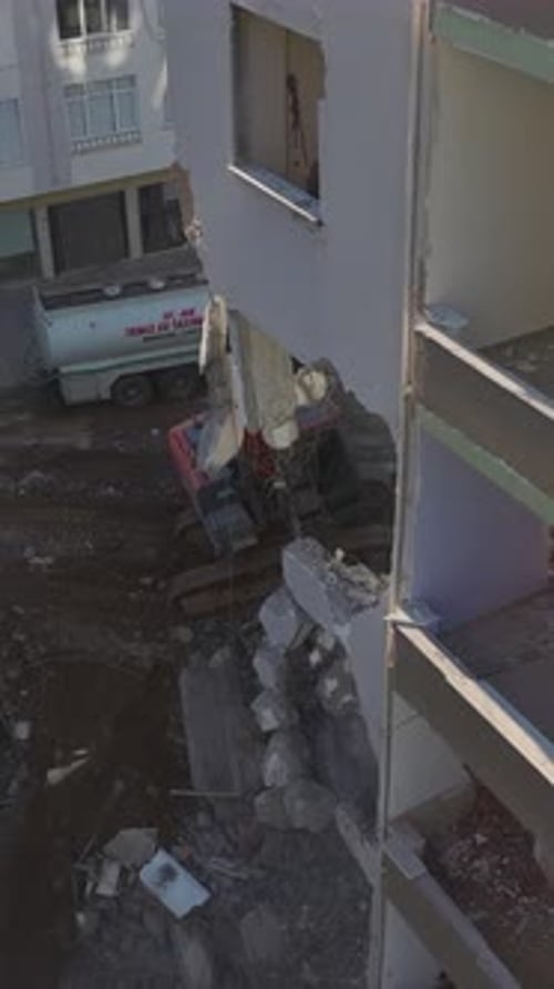 Vertical Video An Excavator Demolishes a Wornout Building Piece By Piece Clearing the Land for a New