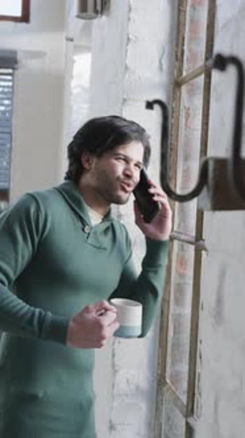 Young Man Talking on Phone With Mug