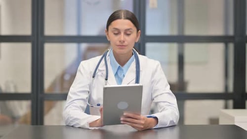 Mixed Race Female Doctor Working on Digital Tablet in Hospital