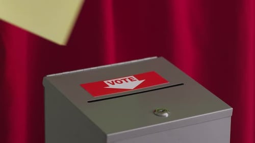 Inserting a vote into the ballot box symbolizing a democratic election
