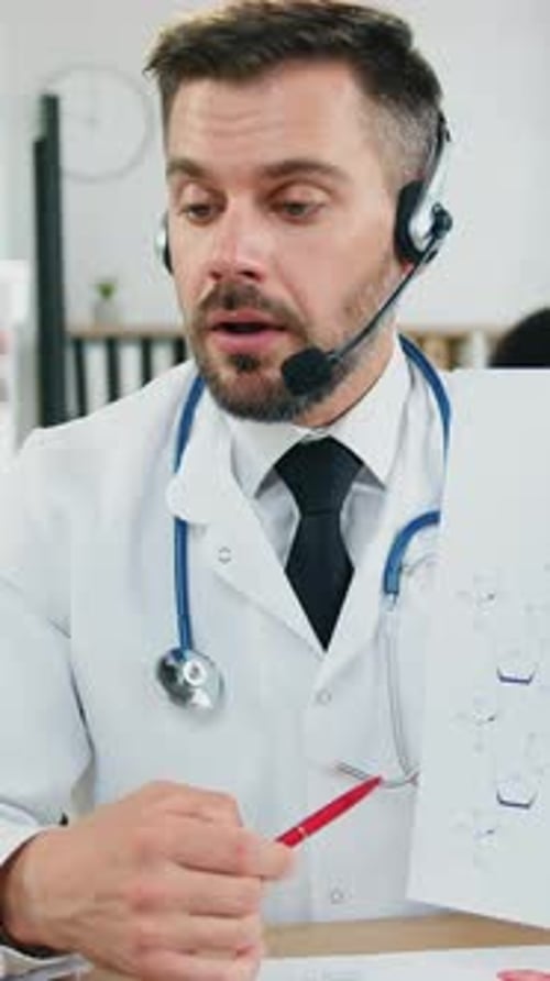 Close Up of Man Doctor Medic in Wireless Headphones Which Sitting in Front of Computer During Online