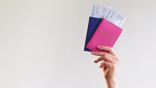 Hand Holding Passports and Plane Tickets for Travel