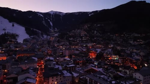 Town Nestled in Snow with Illuminated Rooftops and Lively Streets